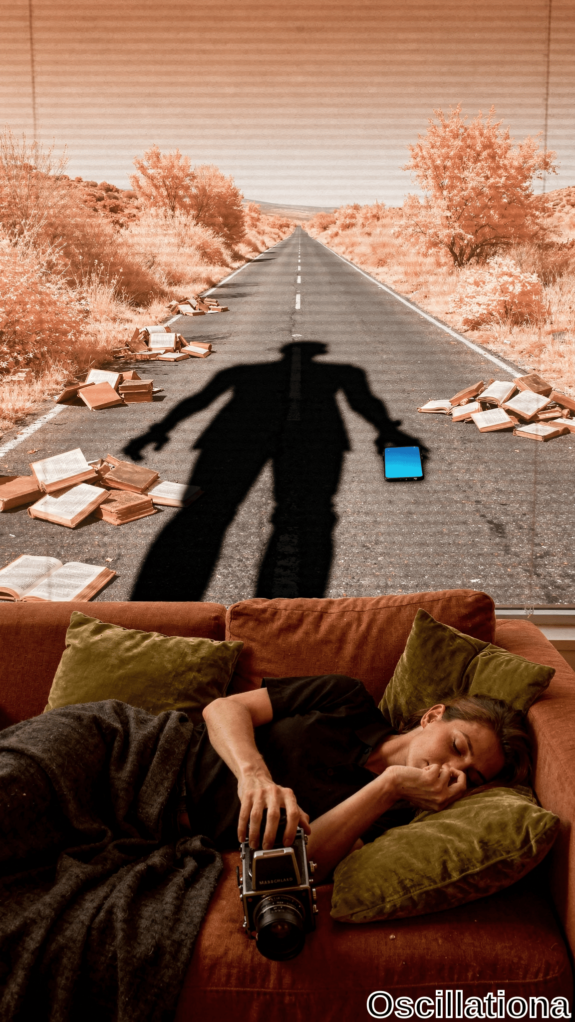 Surreal sepia-orange photo: young woman asleep on rust sofa clutching black Hasselblad camera under gray blanket amid green pillows; through orange blinds, desert road scattered with books, black silhouetted man arms outstretched over glowing blue