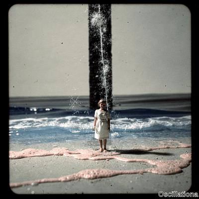 A young blonde girl in white textured dress stands barefoot at waters edge on beach looking at viewer dwarfed by massive black pier piling with splashing waves pink foam on sand in vintage film style with grain scratches. 
.