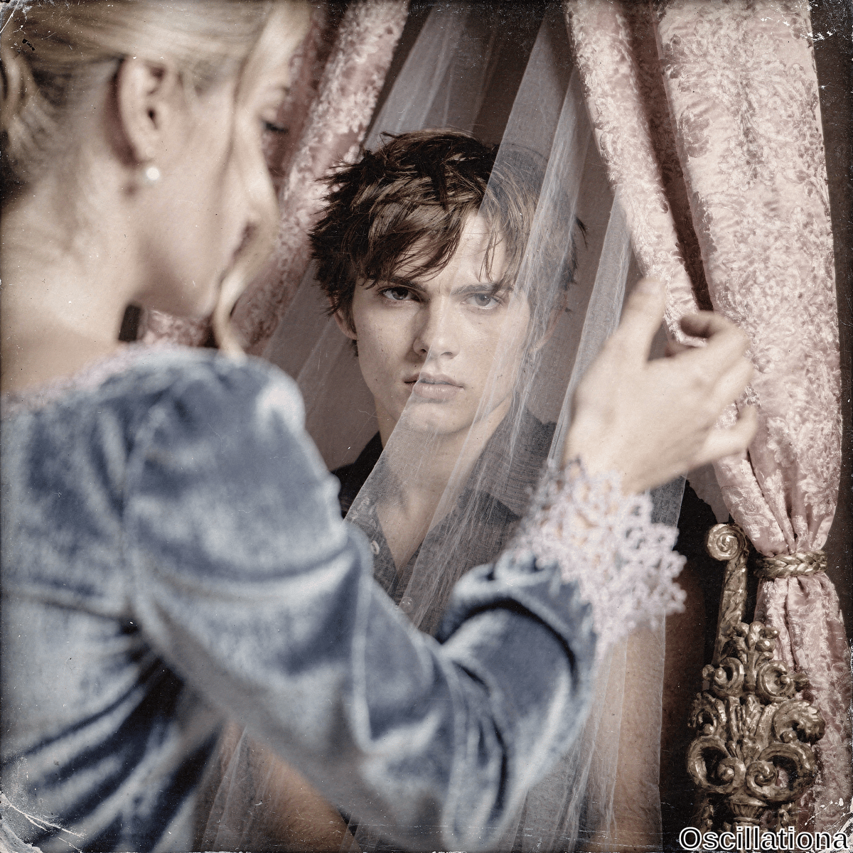 Vintage sepia-toned portrait: blonde woman in profile with loose updo, pearl earring, dusky blue velvet gown & pink lace, parting sheer white veil with pale spread fingers to reveal young man with tousled