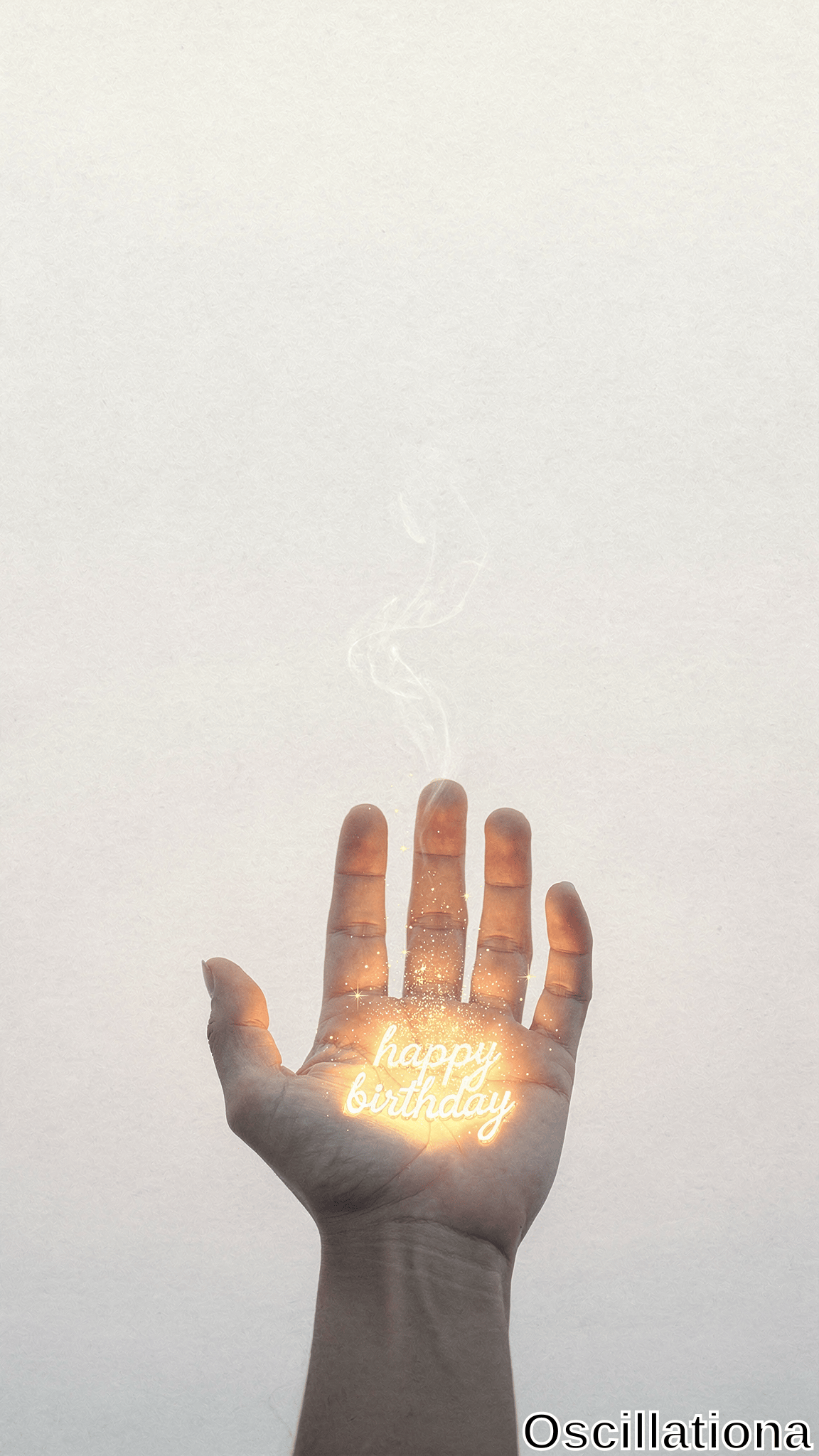 A human hand holds its palm upward, displaying glowing 'happy birthday' text with sparkling particles and thin smoke rising from the fingers against a plain light background.